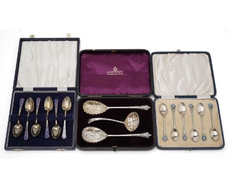 Three cased sets of silver: a set of six silver gilt and blue enamel coffee spoons by Barker Brothers Silver Ltd, Birmingham 