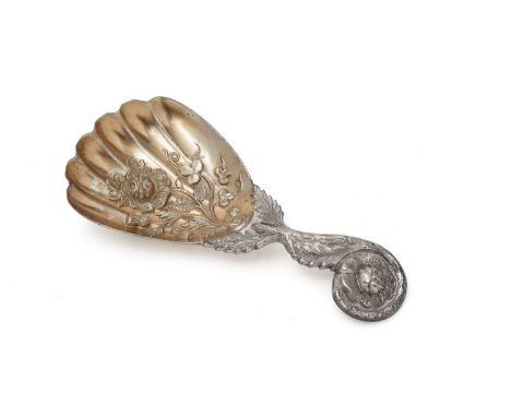 A Victorian provincial silver caddy spoon, with a curly floral stem and a gilt bowl stamped with a rose, thistles and shamroc