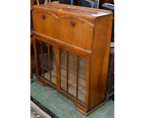 A 1940's walnut veneered bureau/cocktail cabinet, adjacent fall fronts, one enclosing pigeonholes, the other a cocktail cabin