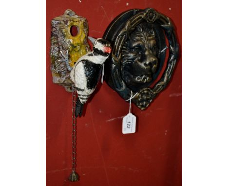 A cast iron lion mask door knocker; another, a woodpecker (2)