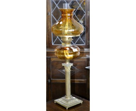 A Victorian Corinthian column oil lamp, amber glass reservoir and shade, Duplex twin burner, with chimney