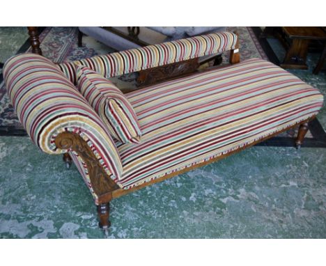 A Victorian scroll arm chaise, padded back rail, leafy carving to splat, turned supports, ceramic casters, circa 1880.