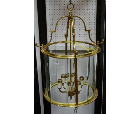 A large brass cylindrical six light hall lantern, bevelled glass panels  