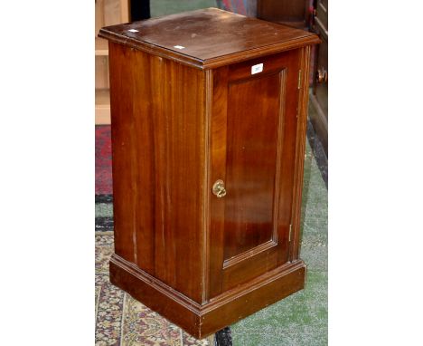 An Edwardian mahogany bedside cupboard, moulded top above a fielded and panelled door enclosing a singular shelf, skirted pli