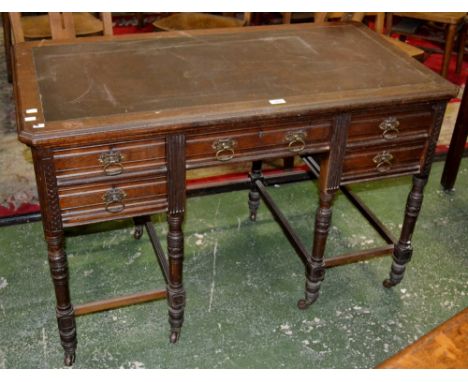 A late Victorian writing desk. canted rectangular leather inlaid moulded top, one long drawer over kneehole flanked by four d