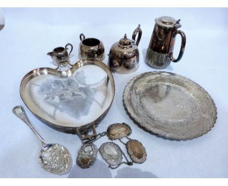 A three piece plated tea service, water jug, four plated bottle labels, two trays and a plated berry spoon