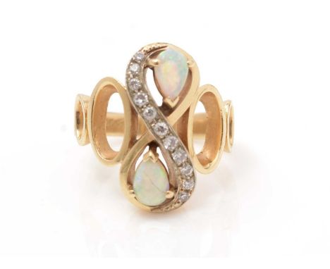 An opal and diamond ring, set with two pear-shaped opal cabochons and eleven brilliant cut diamonds in figure-of-eight mount,