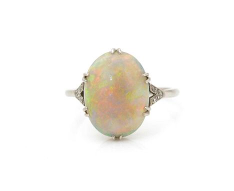 A first half 20th Century opal ring, the oval opal cabochon measuring 13.8 x 10.7 x 4.2mm, flanked by eight-cut diamond shoul