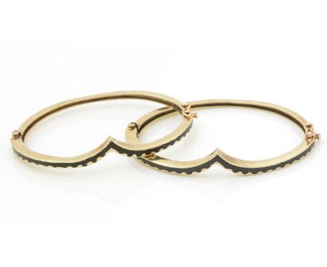 A pair of 14ct yellow gold and black enamel bangles, of wishbone form with wavy design, 6.4cms wide, 23.3g gross. 