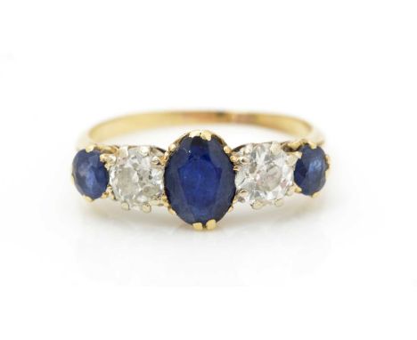 A sapphire and diamond ring, the three oval facet cut sapphires parted by two old cut diamonds weighing a total of approximat