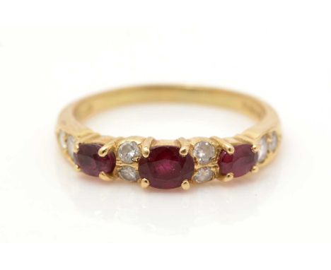 A ruby and diamond ring, set with three graduated oval facet cut rubies and eight brilliant cut diamonds, on 18ct yellow gold