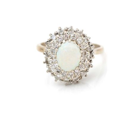 An opal and diamond cluster ring, the oval white opal measuring 8.5 x 6.3mm, surrounded by a double bezel of brilliant cut di