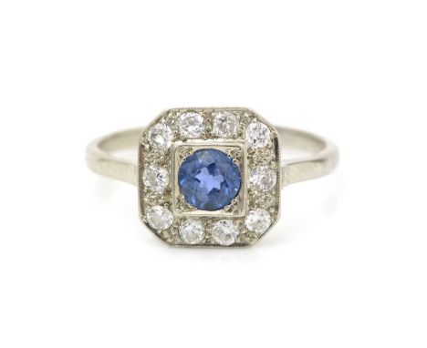 A sapphire and diamond cluster ring, the central circular facet cut sapphire surrounded by old-cut diamonds weighing a total 