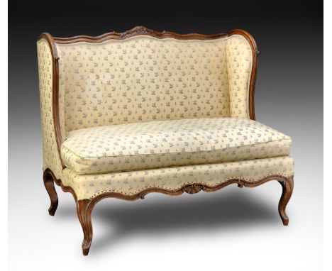 Piccolo sofà ad orecchioni, Francia, metà XVIII secolo cm 101x114x70 In legno di noce, presenta un’elegante sagomatura delle 