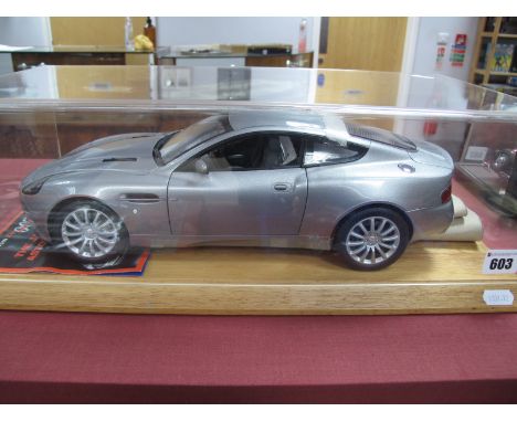 A Kyosho 1:12th Scale Diecast Model Aston Martin V12 Vanquish James Bond 007, presented on a wooden plinth within a perspex d