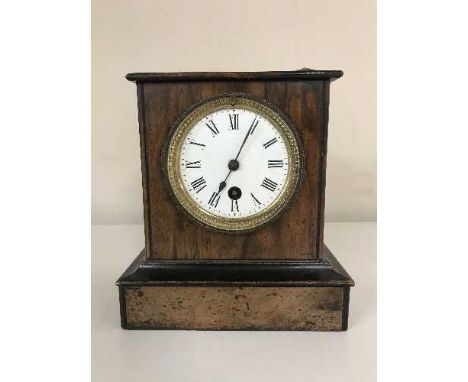 An antique mahogany and pine mantle clock with enamelled dial, pendulum and key