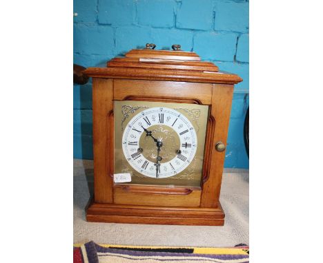 A wooden cased mantle clock with key in working order 