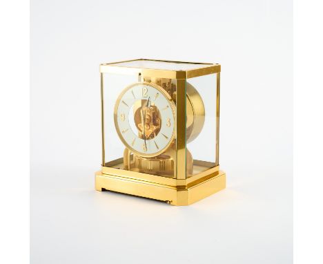 ATMOS. Jaeger LeCoultre. Technik: Kristallglas, vergoldetes Messing u.a. Beschreibung: Verglastes Gehäuse. Weiß lackiertes Ri