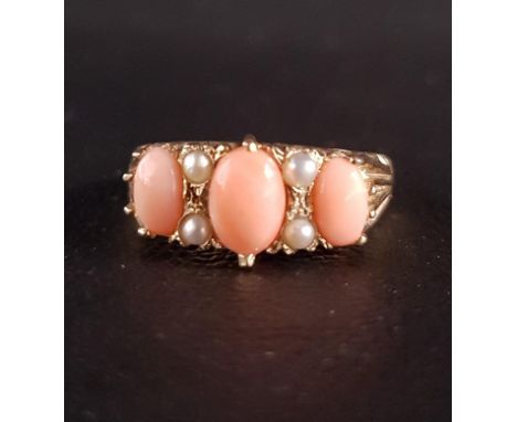 CORAL AND SEED PEARL RINGthe three graduated oval cabochon coral sections separated by seed pearls, on nine carat gold shank,