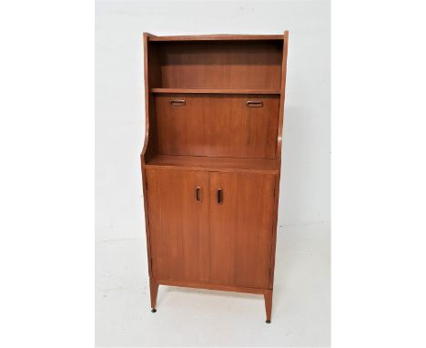 1970s TEAK ILLUMINATED CABINETwith a shelf above shaped sides and an illuminated shelf with a fall flap below, opening to rev