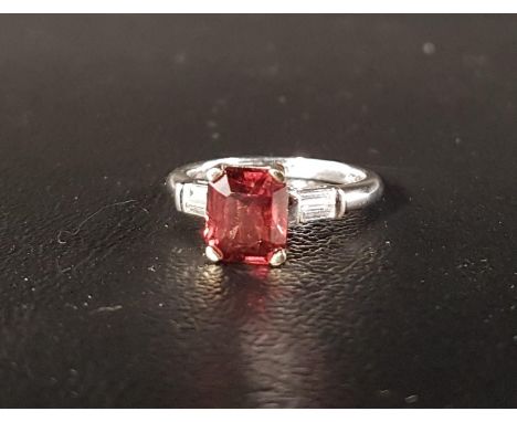 UNUSUAL ORANGE SAPPHIRE AND DIAMOND RINGthe emerald cut sapphire approximately 2.4cts, flanked by baguette cut diamonds to th