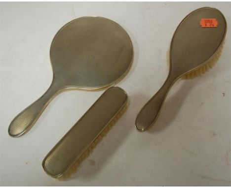 A mid 20th century silver backed three piece dressing table set having engine turned decoration