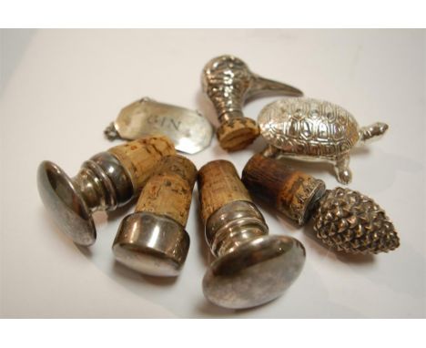 A pair of early 20th century white metal bottle stoppers by Christofle; together with various others and a silver gin decante