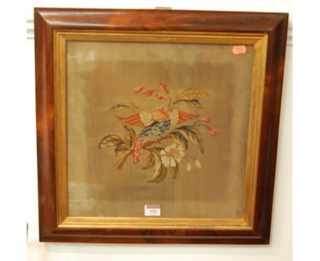 A Victorian embroidered panel depicting a bird amongst flowers in rosewood frame