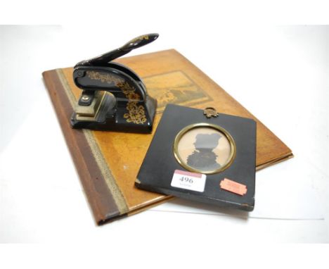 A Victorian portrait silhouette of a lady; together with a iron desk seal; and a leather bound blotter (3)