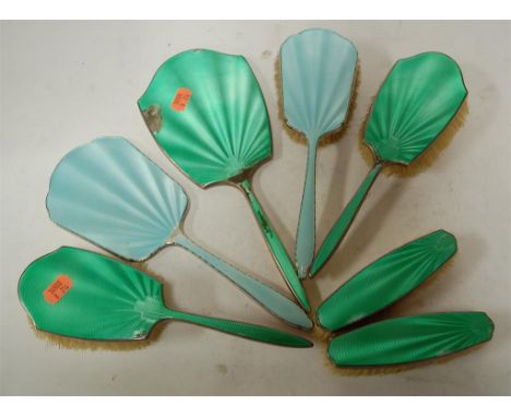 A 1930s silver and green guilloche enamel four piece dressing table set together with one other hand mirror and matching brus