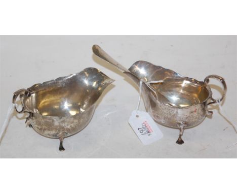An Edwardian silver cream boat having a flying C-scroll handle on hoof feet, London 1902, together with one other similar exa