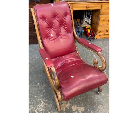 A Regency mahogany open armchair, button upholstered red vinyl, on brass casters