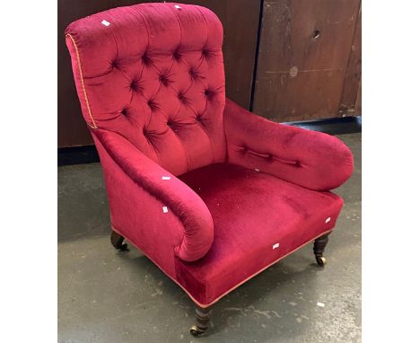 A red velvet upholstered button back armchair, on turned legs and all brass casters stamped Hinkley Welbeck Street London, 79