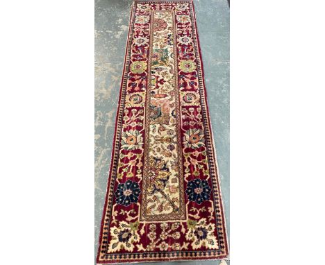A red ground runner rug, 310x86cm