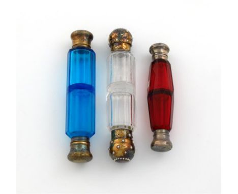 A Victorian silver-gilt mounted double-ended scent bottle, unmarked, cylindrical form, faceted clear glass body, the covers s