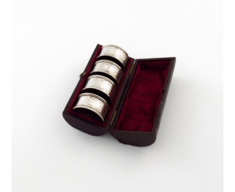 A cased set of four Victorian silver napkin rings, by H. Atkins, Sheffield 1880, circular form, with engine-turned and foliat