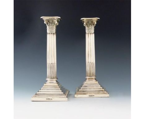 A pair of late-Victorian silver candlesticks, by Walker and Hall, Sheffield 1900, Corinthian column form, on stepped square b