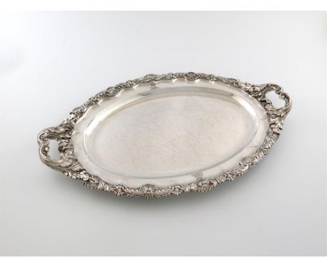 A George III silver two-handled meat platter, by Paul Storr, London 1817, oval form, foliate and shell border, engraved with 