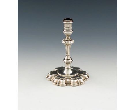 A George II cast silver taper stick, possibly by John Fossey, London 1740, knopped stem with fluted shoulders, spool shaped c