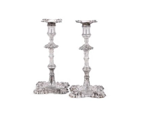 A PAIR OF GEORGE II CAST SILVER CANDLESTICKS WILLIAM GRUNDY, LONDON 1759 The shaped square sconces engraved with a crest, ree