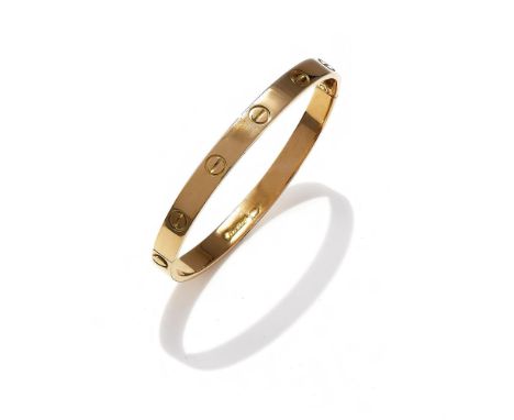CARTIER, A 'LOVE' BANGLE The polished bangle with screwhead motifs, signed Cartier, numbered 402584, stamped 750, maker's pou