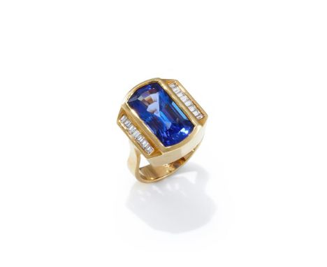 A TANZANITE AND DIAMOND DRESS RING The curved rectangular cut tanzanite collet set between channel set baguette cut diamond s