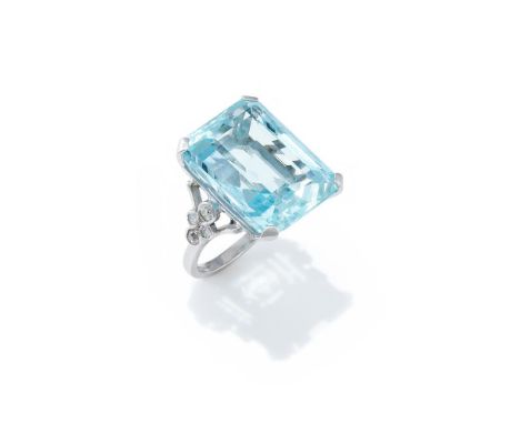 AN AQUAMARINE AND DIAMOND DRESS RING The rectangular step cut aquamarine with canted corners, between trifurcated shoulders s