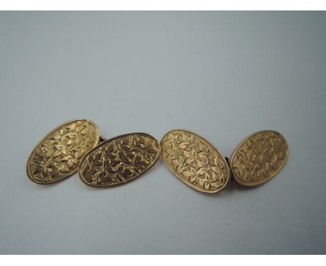 A pair of Edwardian 9ct gold cufflinks of oval form having engraved foliate decoration and chain connectors, Chester 1908 hal
