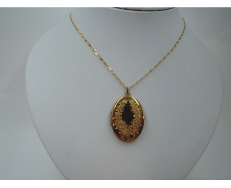 A 9ct gold oval locket having engraved floral decoration to front, on a 9ct gold figaro chain, approx 22' &amp; 9.7g