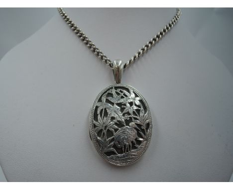 A white metal oval locket having overlaid crane decoration on a long white metal curb link chain stamped sterling, approx 64g