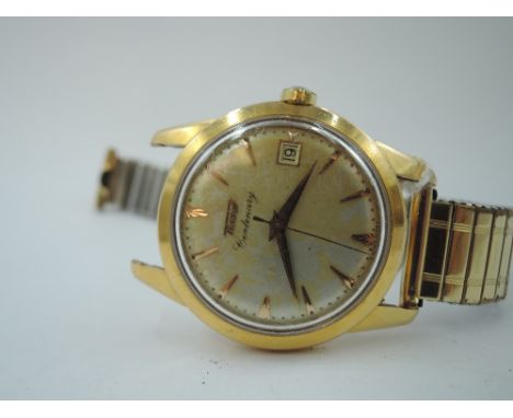A gent's 1950/60's yellow metal wrist watch by Tissot, model Centenary, having a baton numeral dial with sweeping second hand