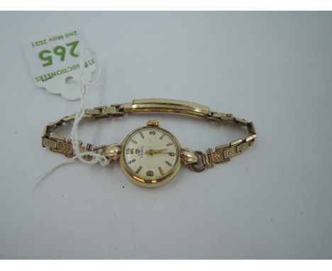 A lady's 9ct gold Tissot wrist watch having Arabic and baton numeral dial in gold case with rolled gold bracelet strap