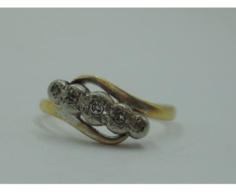 A lady's dress ring having 5 diamond chips in an illusionary setting to cross over shoulders on a yellow metal loop stamped 1