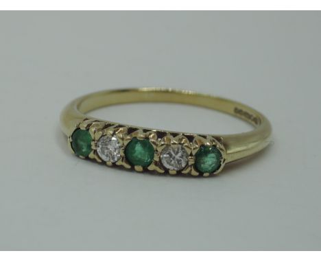 A five stone diamond and emerald dress ring having three emeralds interspersed by two diamonds in a raised mount on a 9ct gol